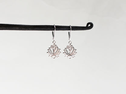 Silver lotus flower earrings on a black hook against a white background