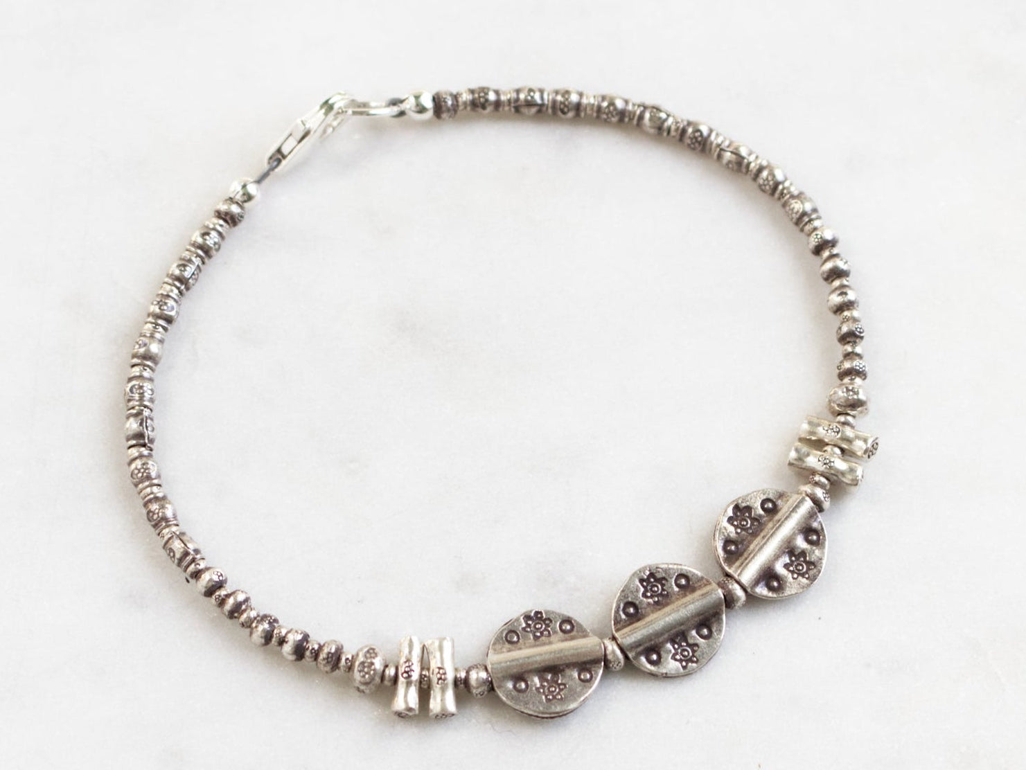 Silver beaded bracelet on a white background