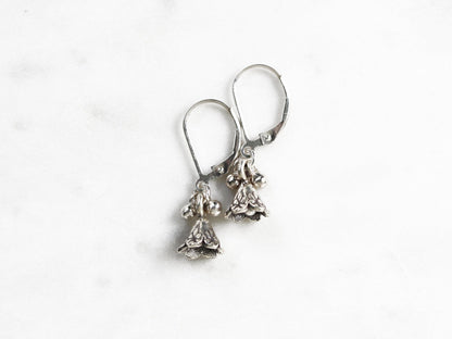 Pair of silver earrings with small stones on a white background